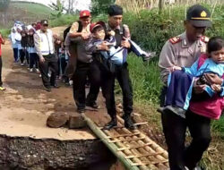Polisi Bantu Warga Melintasi Jalan Amblas Penghubung di Desa Girimulya