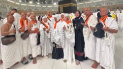Jemaah umrah Jazirah Nusantara Global berpose di depan Kabah.